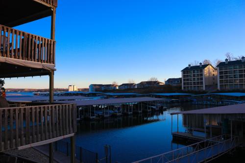 a view of a marina with buildings and water at Daylight Cove Lakefront Condo, Pool, Hot Tub! in Lake Ozark