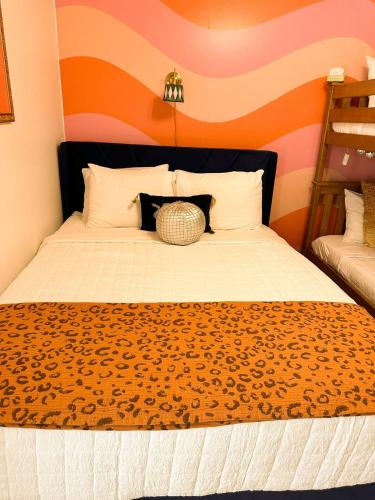 a bedroom with a large bed with an orange wall at Daylight Cove Lakefront Condo, Pool, Hot Tub! in Lake Ozark