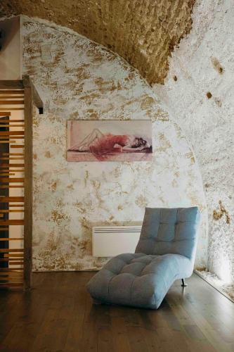 a living room with a blue couch and a painting at TÉGED VÁRTALaK in Dörgicse