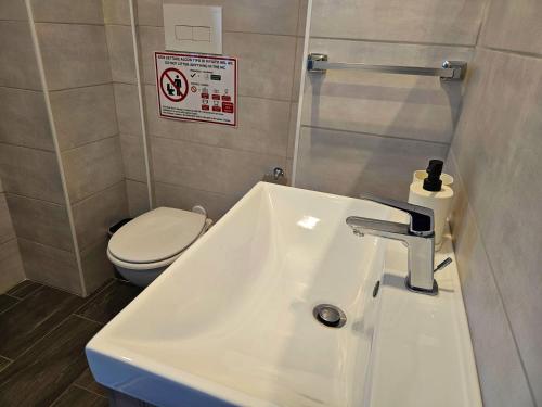 a bathroom with a white sink and a toilet at MiPA in Milazzo