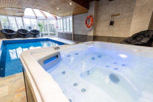 a large tub in a room with a swimming pool at Southview Spa Windermere in Windermere
