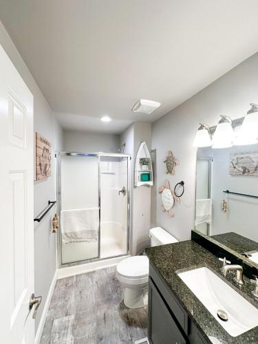 a bathroom with a shower and a toilet and a sink at Knolls Worries-Condo/2BD/2BA/Pool/Deck/Dock/Grill/BoatSlip/Tennis-8PP in Osage Beach