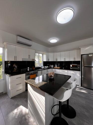 a kitchen with white cabinets and a black counter top at Apartamento Carey in Cabrera