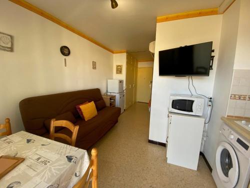 Elle comprend un petit salon doté d'un canapé et d'une télévision. dans l'établissement Appartement cosy avec balcon et climatisation à Balaruc-les-Bains - FR-1-503-179, à Balaruc-les-Bains