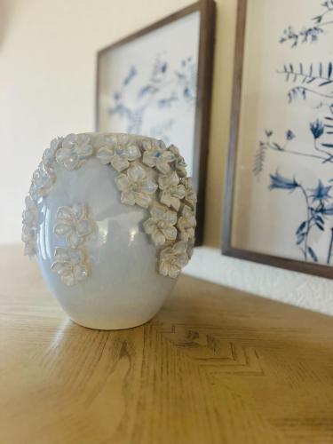 a white vase sitting on a wooden floor in a room at The Overlook At Cedar Point in Osage Beach