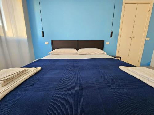 a blue bedroom with a large bed with blue walls at MiPA in Milazzo