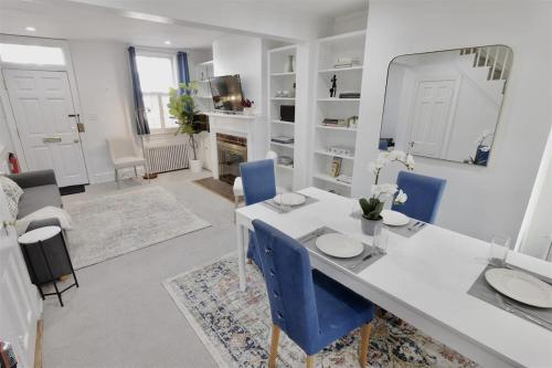a living room with a white table and blue chairs at Georgetown Cobblestone Cottage - Private Parking in Washington, D.C.