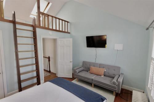 una camera da letto con un letto, un divano e una TV di Georgetown Cobblestone Cottage - Private Parking a Washington