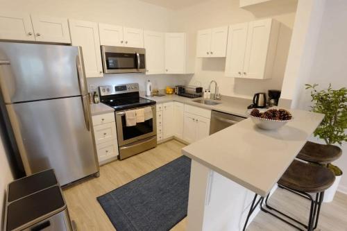 a kitchen with white cabinets and a stainless steel refrigerator at The Grand Dame of Shaw-Between Shaw & Logan Circle in Washington, D.C.