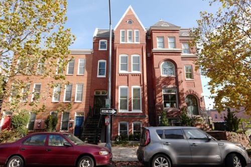 a red car parked in front of a brick building at The Grand Dame of Shaw-Between Shaw & Logan Circle in Washington, D.C.