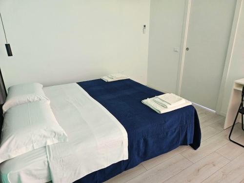 a bedroom with a bed with blue and white sheets at MiPA in Milazzo