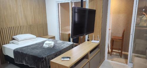 a room with a bed and a flat screen tv at FLATS - DUO JK in Sao Jose do Rio Preto