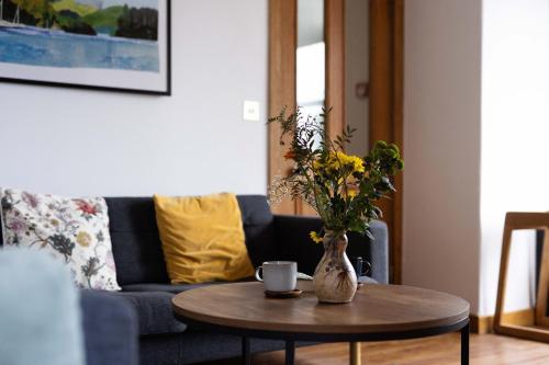 a living room with a table with a vase with flowers at Southview Spa Windermere in Windermere