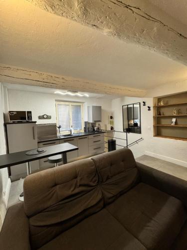 un salon avec un canapé et une cuisine dans l'établissement Maison de village St Paul de Vence, à Saint-Paul-de-Vence