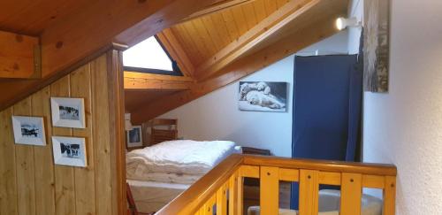 une chambre avec un lit dans un grenier dans l'établissement Le petit Pinson, à Font-Romeu-Odeillo-Via