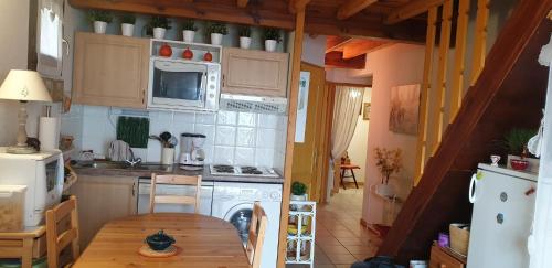 Il comprend une cuisine équipée d'une table, d'une cuisinière et d'un four micro-ondes. dans l'établissement Le petit Pinson, à Font-Romeu-Odeillo-Via