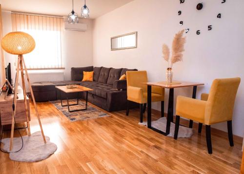 a living room with a couch and a table and chairs at Apartman Royal 4 in Doboj