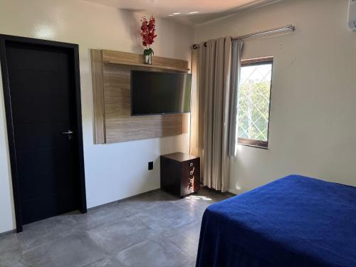 a bedroom with a bed and a flat screen tv at Prédio Green Hall in Toledo