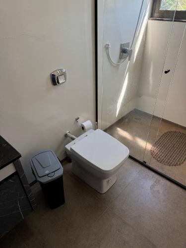 a bathroom with a toilet and a glass shower at Prédio Green Hall in Toledo