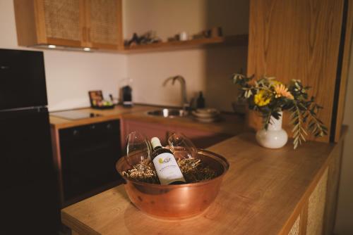 a kitchen counter with a bowl with wine bottles on it at Ampeli Villas in Néa Artáki