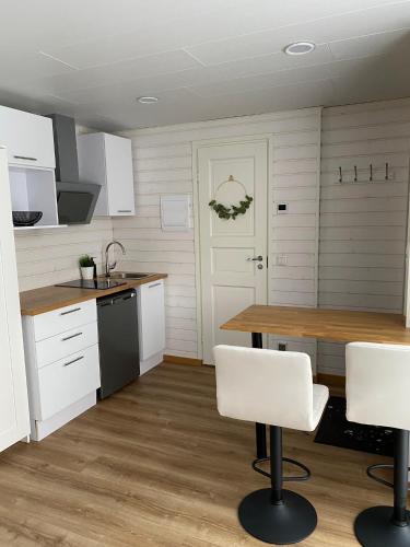 a kitchen with white cabinets and a table and chairs at Jaama Villa Studio Flat Surrounded by Garden in Tartu