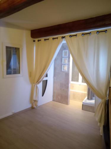 a room with curtains in a room with a window at Studio magnolia in Sainte-Anastasie-sur-Issole