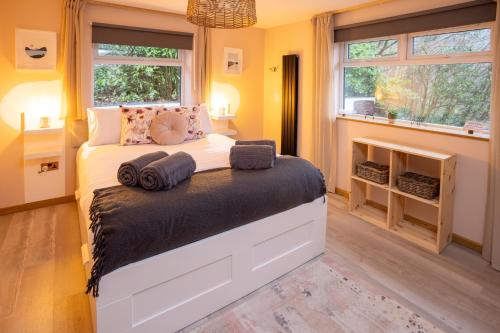 a bedroom with a bed in a room with windows at Southview Spa Windermere in Windermere