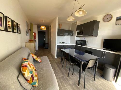 un salon et une cuisine avec un canapé et une table dans l'établissement Appartement 2 étoiles climatisé avec balcon, proche Thermes, animaux admis - FR-1-503-37, à Balaruc-les-Bains