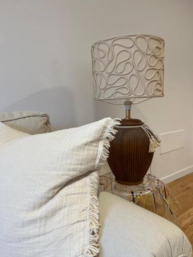 a lamp sitting on a table next to a bed at Daniela Luxury Apartment in Rome