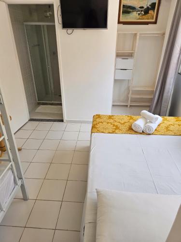 a room with a bed and towels on a counter at Pousada Rota do Sol in Cabo Frio