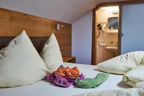 a bed with two stuffed animals sitting on it at Apart & Pension Wassermann inklusive Sommerbergbahnticket in Tannheim