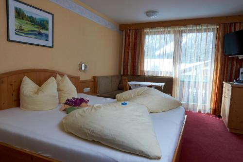 a hotel room with two beds with pillows at Apart & Pension Wassermann inklusive Sommerbergbahnticket in Tannheim