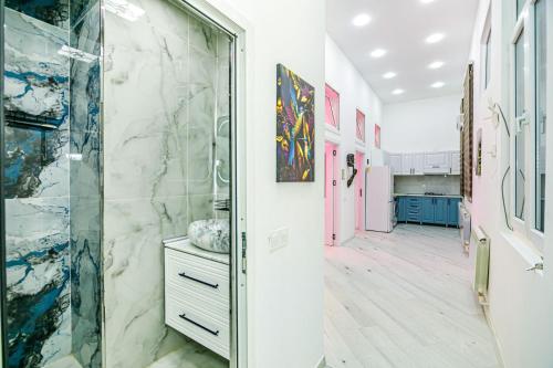 バクーにあるMalakan Nizami City Hotel Baku And Apartments Familyのバスルーム(ガラスドアの隣にウォークインシャワー付)