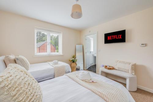 a bedroom with two beds and a sign that readsnight at Detached House in Brooklands - Prime Location - Driveway Parking, Self-Check-In, Fast WiFi and Smart TV by Yoko Property in Milton Keynes
