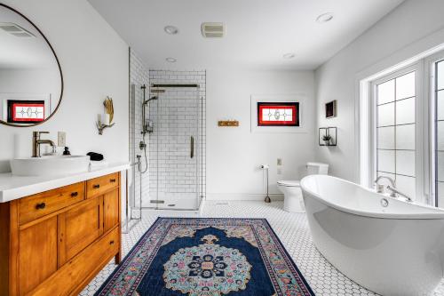 a bathroom with a tub and a sink and a toilet at The Abundance Suite at Dream BNB Estate Inn in Leamington