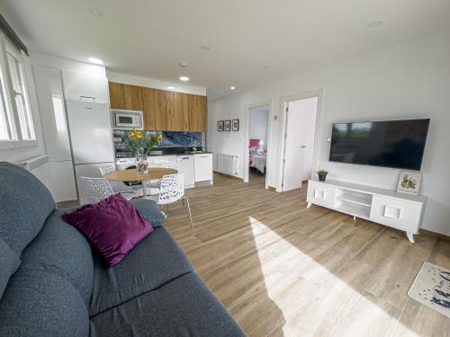 a living room with a couch and a table and a television at Villa Nela Loredo in Loredo