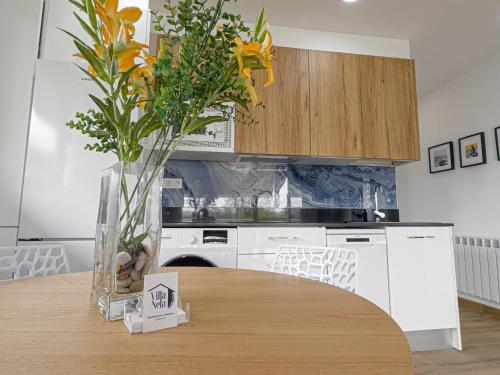 a kitchen with a table with a vase of flowers at Villa Nela Loredo in Loredo