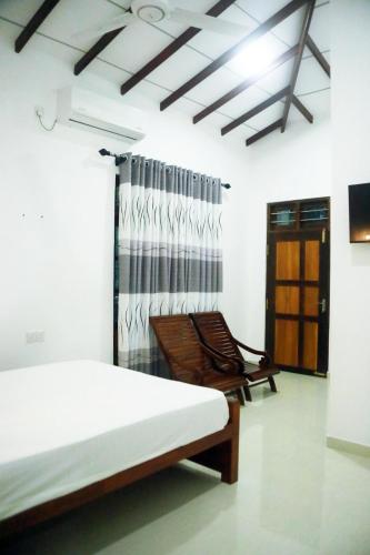 a bedroom with a bed and a chair in it at Sun Palace Yala in Tissamaharama