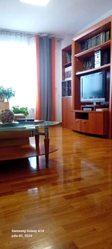 a living room with a table and a tv at Apartamento en Sada in Santa María