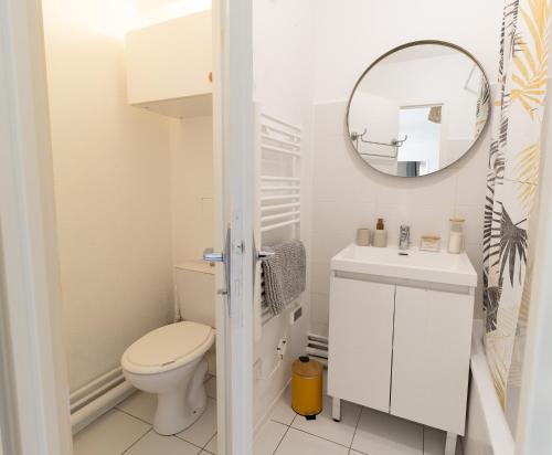 La salle de bains blanche est pourvue de toilettes et d'un miroir. dans l'établissement L'envolée - Appartement entier avec Balcon & Parking privé - SO COZY, à Toulouse