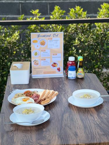 a wooden table with two plates of food on it at Sunny Side Resort Koh Tao in Koh Tao