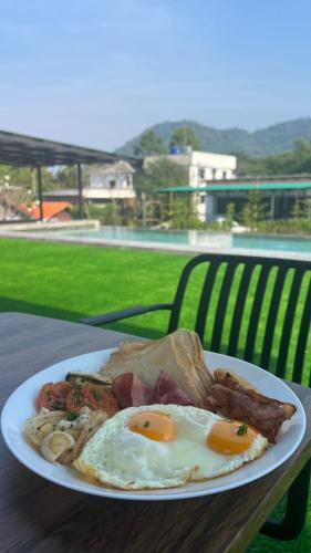 a plate of food with eggs and bacon on a table at Sunny Side Resort Koh Tao in Koh Tao