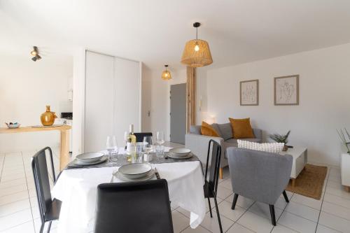 une salle à manger et un salon avec une table et des chaises dans l'établissement L'envolée - Appartement entier avec Balcon & Parking privé - SO COZY, à Toulouse