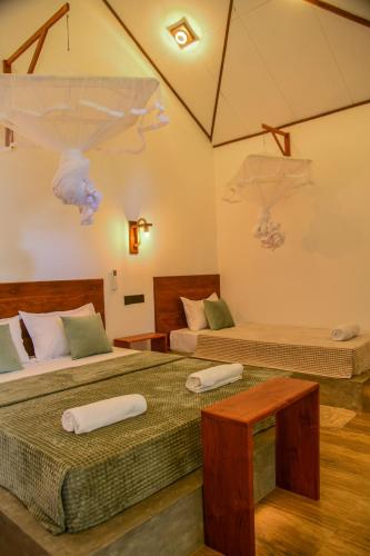 two beds in a room with two bedsitures at EdenHaven Cottage in Udawalawe