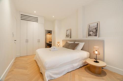 - une chambre blanche avec un lit blanc et une table dans l'établissement Luxury apartment of 140 sqm, à Paris