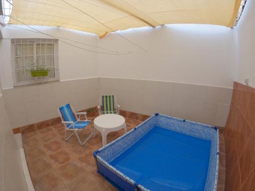 Zimmer mit blauer Badewanne, Tisch und Stühlen in der Unterkunft Departamento a metros del Parque Central de Mendoza in La Cieneguita