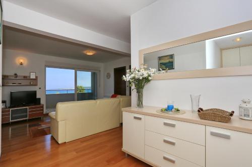 een keuken en een woonkamer met een bank en een televisie bij Apartment Puntamika in Zadar
