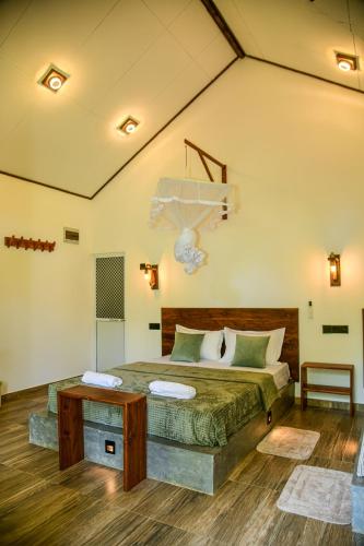 a bedroom with a bed and a table at EdenHaven Cottage in Udawalawe
