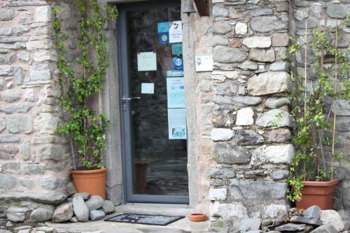 a door of a stone building with potted plants at Eremo Gioioso in Pontremoli