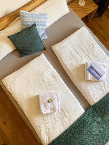 a bed with white blankets and pillows on it at Gasthaus Canow in Wustrow